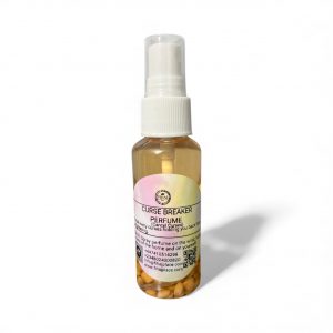 Small spray bottle labeled ‘Curse Breaker Perfume’ with light amber liquid and seeds at the bottom, photographed on a white background.”